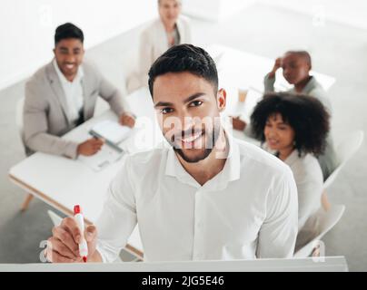 Ont créé quelque chose de formidable. Photo d'un jeune homme d'affaires écrivant sur un tableau blanc pendant une réunion au travail. Banque D'Images