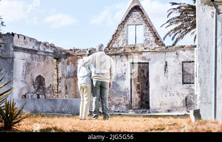 L'assurance est le meilleur investissement. Prise de vue d'un couple senior se réconfortant après avoir perdu sa maison à un incendie. Banque D'Images