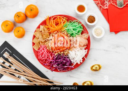 Salmon Yee sang ou Yusheng, a Prosperity Toss Dishfor Chinese New Year Celebration, fait de divers légumes colorés déchiquetés et saumon en tranches, p Banque D'Images