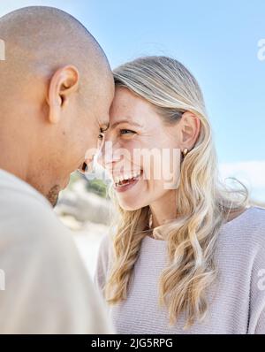 Couple intime romantique collage pendant une date. Homme et femme interracial affectueux mûrs riant et passant du temps ensemble à la plage debout Banque D'Images
