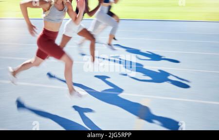 L'ombre des athlètes qui s'entraînent et s'entraînent ensemble sur un circuit sportif. Gros plan sur les coureurs actifs et les coureurs en forme de course à pied ou de course à pied sur un terrain. Les personnes s'exerçant Banque D'Images