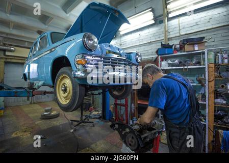 SAINT-PÉTERSBOURG, RUSSIE - le 03 AOÛT 2020 : un mécanicien d'automobiles répare le moteur de la voiture rétro soviétique de Moskvich-403 Banque D'Images