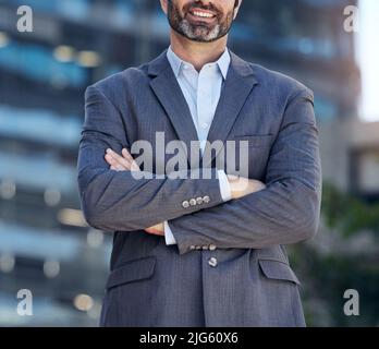 Voulez parler affaires. Photo d'un homme d'affaires méconnu debout avec ses bras croisés sur un fond de ville. Banque D'Images