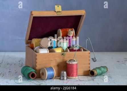 Encore la vie avec des accessoires de couture et une boîte. Vintage. Banque D'Images