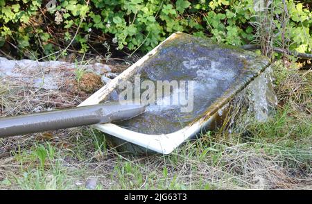 ancienne baignoire abandonnée avec tuyau d'eau pour arroser le bétail sur la ferme Banque D'Images