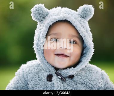 Ne vous contentez pas de câliner cette cravate. Portrait d'un adorable bébé garçon portant une veste à fourrure avec des oreilles d'ours à l'extérieur. Banque D'Images