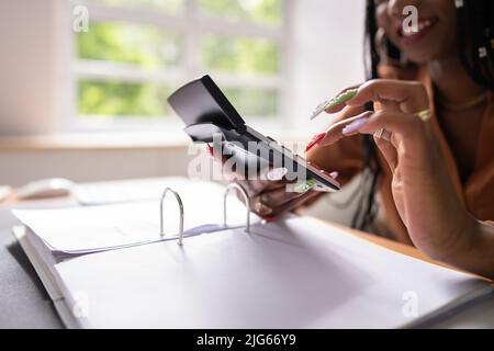 Image rognée d'une femme d'affaires calculant la taxe au bureau Banque D'Images