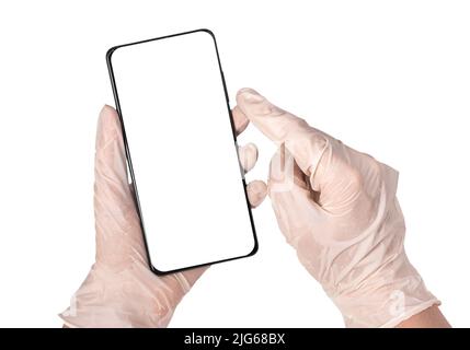 Médecin mains dans des gants tenant le téléphone maquette isolée sur fond blanc. Communication en ligne avec le patient, à l'aide d'une application médicale dans les concepts de smartphone, de télésanté et de télémédecine. Photo de haute qualité Banque D'Images