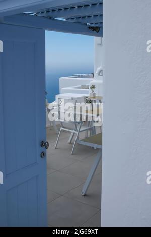 Une entrée à une belle terrasse extérieure d'un restaurant avec chaises et tables et une vue imprenable sur la mer Égée à Santorin Banque D'Images