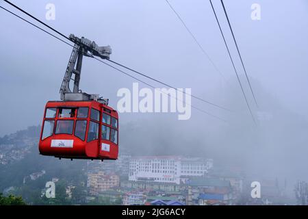 Gangtok, Sikkim - 16 juin 2022, les touristes apprécient un téléphérique au-dessus de la ville de Gangtok. Magnifique paysage urbain aérien de Sikkim. Couvert de brume ou de brouillard. Banque D'Images