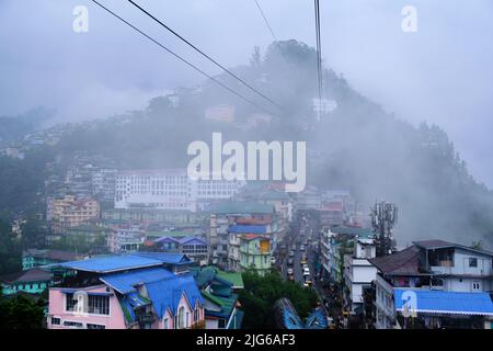 Gangtok, Sikkim - 16 juin 2022, les touristes apprécient un téléphérique au-dessus de la ville de Gangtok. Magnifique paysage urbain aérien de Sikkim. Couvert de brume ou de brouillard. Banque D'Images