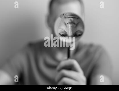 Psychologie concept de perception de soi déformée. Homme avec loupe et faux reflet à l'envers. Photo de haute qualité Banque D'Images