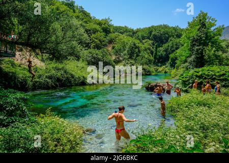 Muzina, Albanie - les touristes se baignent dans le Syri i Kaltër, L'OEIL BLEU, est avec 6 m³/s l'eau la plus riche source du pays. L'eau sort de Banque D'Images