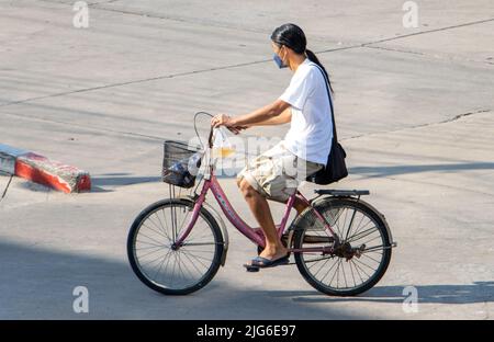 SAMUT PRAKAN, THAÏLANDE, APR 15 2022, Une femme sur un vélo dans la rue de la ville. Banque D'Images