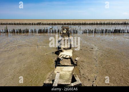 Un sentier en béton démoli sur des piliers au bout du chemin avec l'horizon de la mer. Banque D'Images