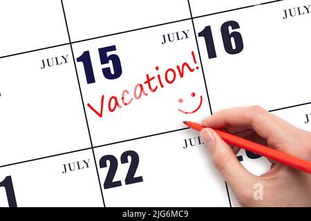 15th jour de juillet. Une main écrivant un TEXTE DE VACANCES et dessinant un visage souriant sur une date de calendrier 15July. Concept de planification des vacances. Mois d'été, jour de Banque D'Images