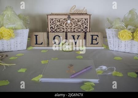 Un livre d'invité de mariage disposé sur une table à une réception de mariage avec un signe de lecture amour Banque D'Images