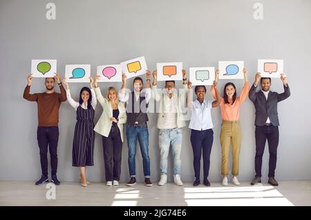 Groupe de gens heureux et divers tenant des bannières avec des ballons de discours et des bulles de message Banque D'Images