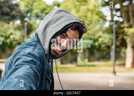 Suivez-moi concept. Un jeune homme souriant qui marche à l'extérieur tient ses amies la main. L'homme dirige la femme Banque D'Images