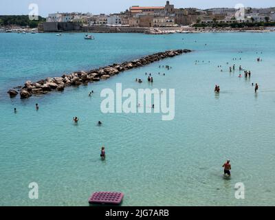 Vue panoramique sur la baie d'Otrante pendant l'été avec les baigneurs profitant de l'eau turquoise avec la ligne d'horizon d'Otrante au loin Banque D'Images