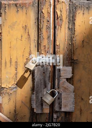 Plusieurs serrures attachées à une porte en bois battue par le temps à une vieille maison dans la ville de Nardo, Puglia, Italie. Banque D'Images