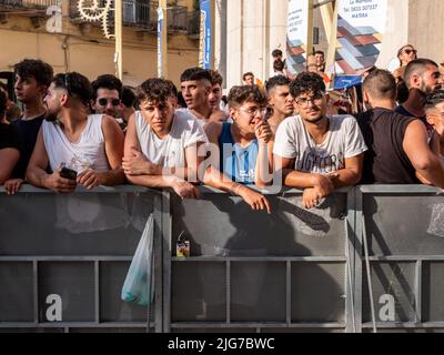 Des foules et des jeunes hommes attendent la procession de la Madonna brune à Matera, en Italie, afin d'attaquer le flotteur portant la sainte statue Banque D'Images