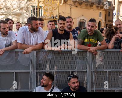 Des foules et des jeunes hommes attendent la procession de la Madonna brune à Matera, en Italie, afin d'attaquer le flotteur portant la sainte statue Banque D'Images