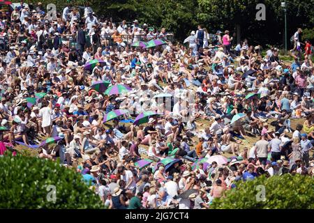 Les spectateurs se protègent du soleil le douze jour des Championnats de Wimbledon 2022 au All England Lawn tennis and Croquet Club, Wimbledon. Date de la photo: Vendredi 8 juillet 2022. Banque D'Images