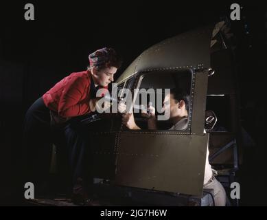 Équipe de rivetage travaillant sur la coque de cockpit d'un B-25 [c.-à-d. C-47] bombardier à l'usine de North American Aviation, Inc., Inglewood [c.-à-d. Douglas Aircraft Company, long Beach], Californie photo montre une femme et un homme travaillant sur une coque de poste de pilotage de Douglas Aircraft Company identifiée comme C-47 selon le contour de la fenêtre. Bien que parfois appelé un « bombardier biscuit », l'avion était pour le transport. Banque D'Images