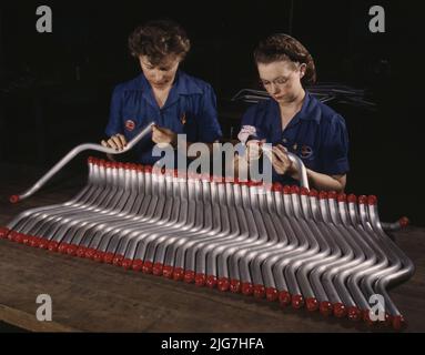 Deux travailleuses sont présentées comme bouchage et inspection de tubes qui entrent dans la fabrication du bombardier de plongée "Vengeance" (A-31) fabriqué à la division de Nashville de Vultee, Tennessee. Le "Vengeance" (A-31) a été conçu à l'origine pour les Français. Il a été adopté plus tard par la R.A.F. et encore plus tard par les forces aériennes de l'armée des États-Unis. Il s'agit d'un avion à un seul moteur, à voilure basse, transportant un équipage de deux hommes et ayant six mitrailleuses de calibres variables. Banque D'Images