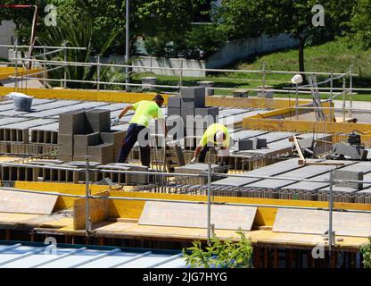 Deux ouvriers de la construction posant un plancher sur un chantier de construction avec 3 blocs de béton de trous Santander Cantabria Espagne Banque D'Images