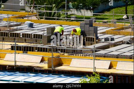 Deux ouvriers de la construction posant un plancher sur un chantier de construction avec 3 blocs de béton de trous Santander Cantabria Espagne Banque D'Images