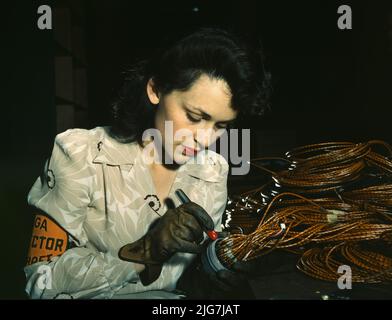 Femme employée d'avion, Vega Aircraft Corporation, Burbank, Californie, montre la vérification des assemblages électriques. Banque D'Images