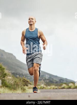 Je ne laisse personne courir ma vie, je la fais. Photo d'un jeune sportif pour une course sur une route de montagne. Banque D'Images