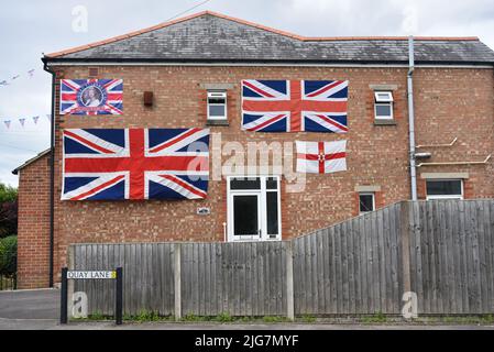 Maison résidentielle anglaise décorée de drapeaux syndicaux et du drapeau irlandais du Nord en commémoration du jubilé de la reine Elizabeth. Banque D'Images