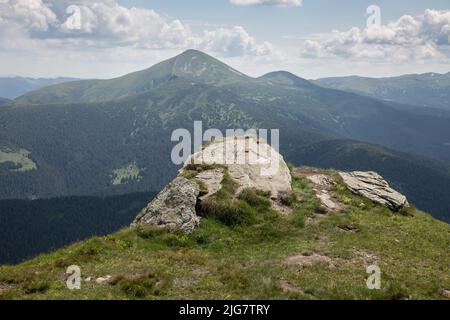 Le sommet du Mont Hoverla est recouvert d'herbe verte et de pierres lors d'une journée ensoleillée, randonnée et tourisme à Carpates, Ukraine Banque D'Images