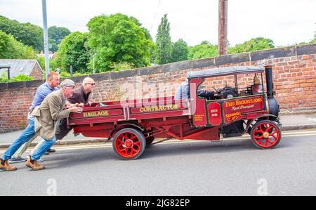 Trois hommes ont poussé un wagon à vapeur au-dessus d'une colline dans le village de Cheshire, en Angleterre, après qu'il ait perdu son pouvoir Banque D'Images