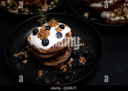 Le petit déjeuner est parfait, des crêpes américaines sont servies sur une table en pierre noire. Banque D'Images