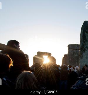 Stonehenge, Stonehenge Down, Amesbury, Wiltshire, 19-12-2012. Vue générale des foules observant le soleil se lever à travers un trilthon à Stonehenge au solstice d'hiver. Banque D'Images