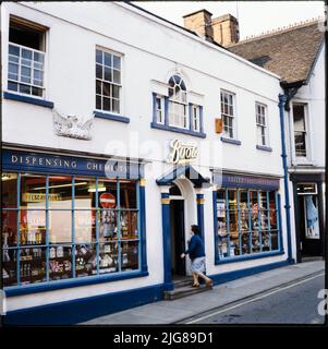 Boots Dispensing Chemists, voie de circulation, Woodbridge, East Suffolk, Suffolk, 1970s-2000s. Une femme entre dans le magasin Boots à 18 voies de circulation. Le bâtiment a été construit à l'origine comme une paire avec 20 voies de circulation au 18th siècle. Le shopping date probablement du début du 19th siècle. Banque D'Images