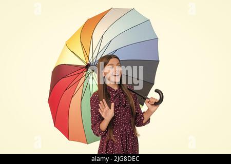 le parasol de protection contre la pluie multicolore, isolé sur fond blanc, se tient un enfant émerveillé bonjour, automne Banque D'Images