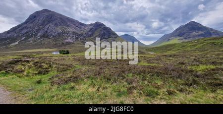 Une vue panoramique sur le champ vert contre les trois sœurs de Glencoe en Écosse Banque D'Images