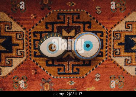 deux pierres peintes oeil mauvais sur le tapis à motifs du moyen-orient Banque D'Images