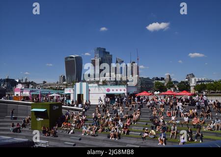 Londres, Royaume-Uni. 8th juillet 2022. Les gens regardent les matchs de tennis de Wimbledon sur un grand écran extérieur près de Tower Bridge à mesure que les températures montent dans la capitale. Credit: Vuk Valcic/Alamy Live News Banque D'Images