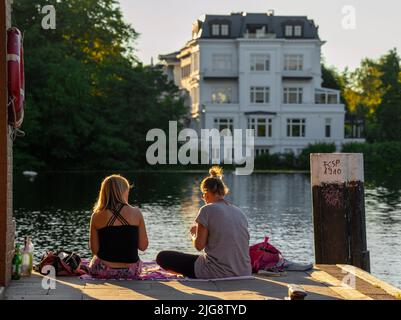 Deux femmes assises sur la rive de l'Alster à Hambourg Banque D'Images