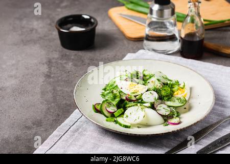 Salade avec concombre, radis, oignon de printemps et œuf. Banque D'Images