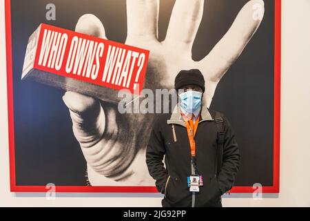 Angleterre, Londres, Southwark, Bankside, Tate Modern Art Gallery, Security Guard devant l'œuvre intitulée « qui possède quoi ? » Par Barbara Kruger Banque D'Images