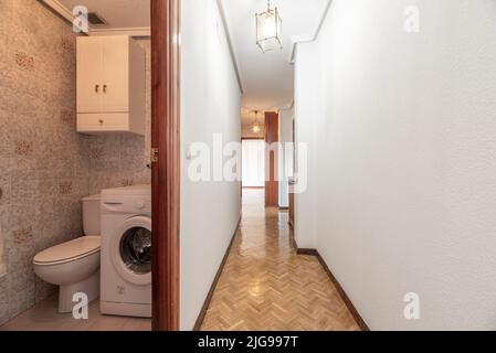 Couloir d'une maison avec plusieurs portes et accès à différentes chambres et salles de bains avec parquet en chêne à chevrons Banque D'Images