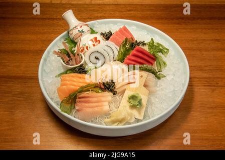 Grand plateau de sushi de bar, sashimi, calmar avec algue, saumon norvégien, babeurre et thon rouge à nageoires jaunes sur beaucoup de glace pilée Banque D'Images