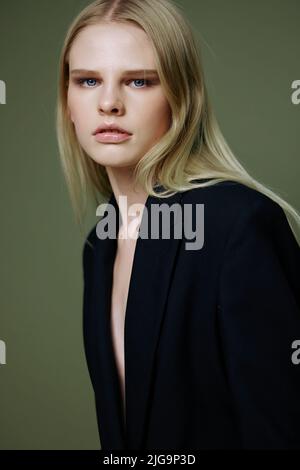 Un portrait rapproché d'une belle fille posant dans un studio sur un fond vert Banque D'Images